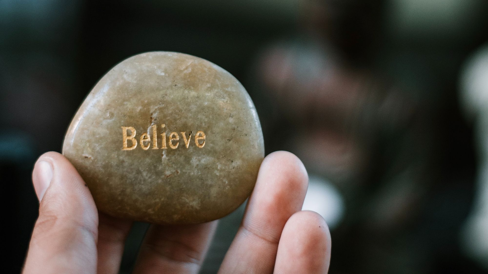 person holding brown stone with believe print photo  Free Human Image on Unsplash
