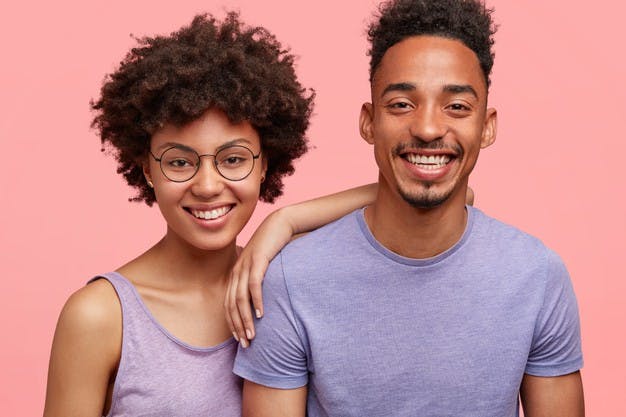 horizontal-shot-happy-african-american-woman-man-have-truthful-relationships-toothy-smile-happy-meet-with-friends-dressed-casually-isolated-pink-wall-emotions-concept_273609-15558.jpg