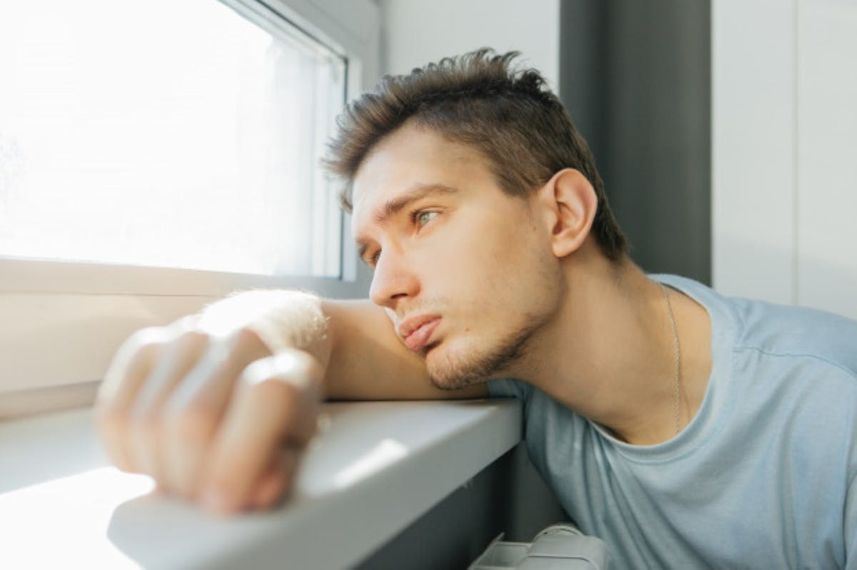 young-man-sadly-looks-out-window-from-his-house-thought_73107-21961.jpg