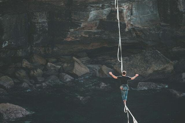 Man walking on tightrope over canyon