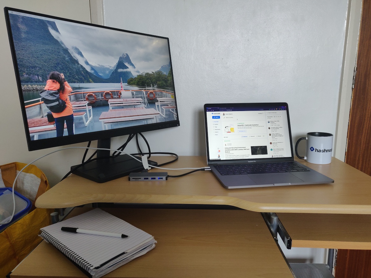 My temporary setup including monitor, laptop, and Hashnode mug