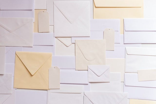 A wall with many different colored envelopes on it.