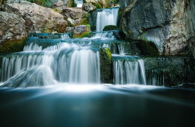 A small waterfall in the middle of a forest.