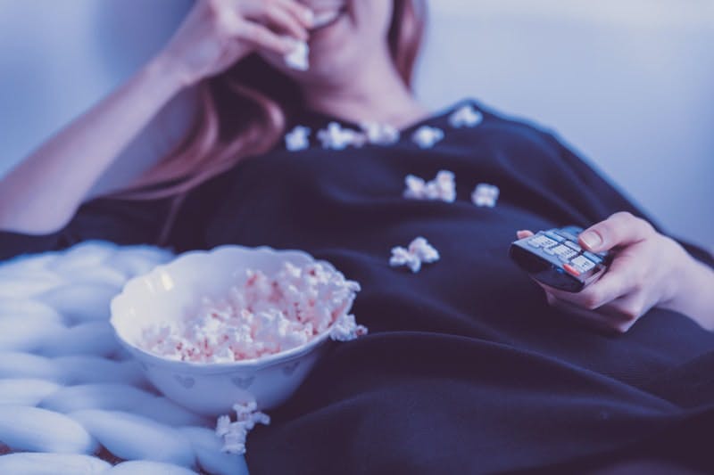 woman-eating-popcorn-and-hold-television-remote-control.jfif