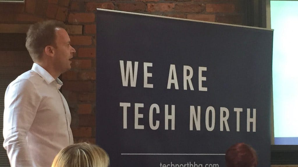 Toby Harper stood in-front of the 'We Are Tech North' sign