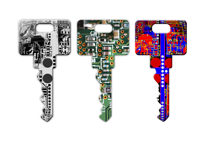 Three keys painted to look like computer circuit boards, one is black and white, the next is green orange and white, the third is red blue and white. 