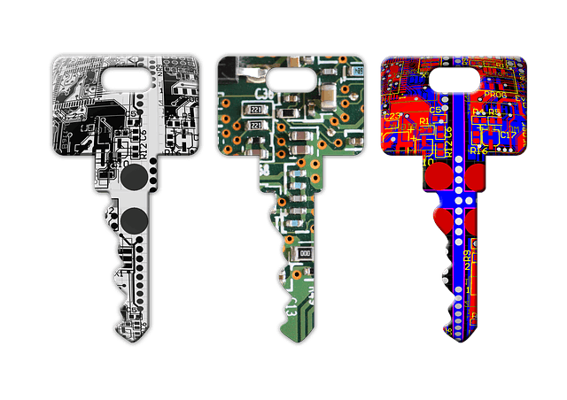 Three keys painted to look like computer circuit boards, one is black and white, the next is green orange and white, the third is red blue and white. 
