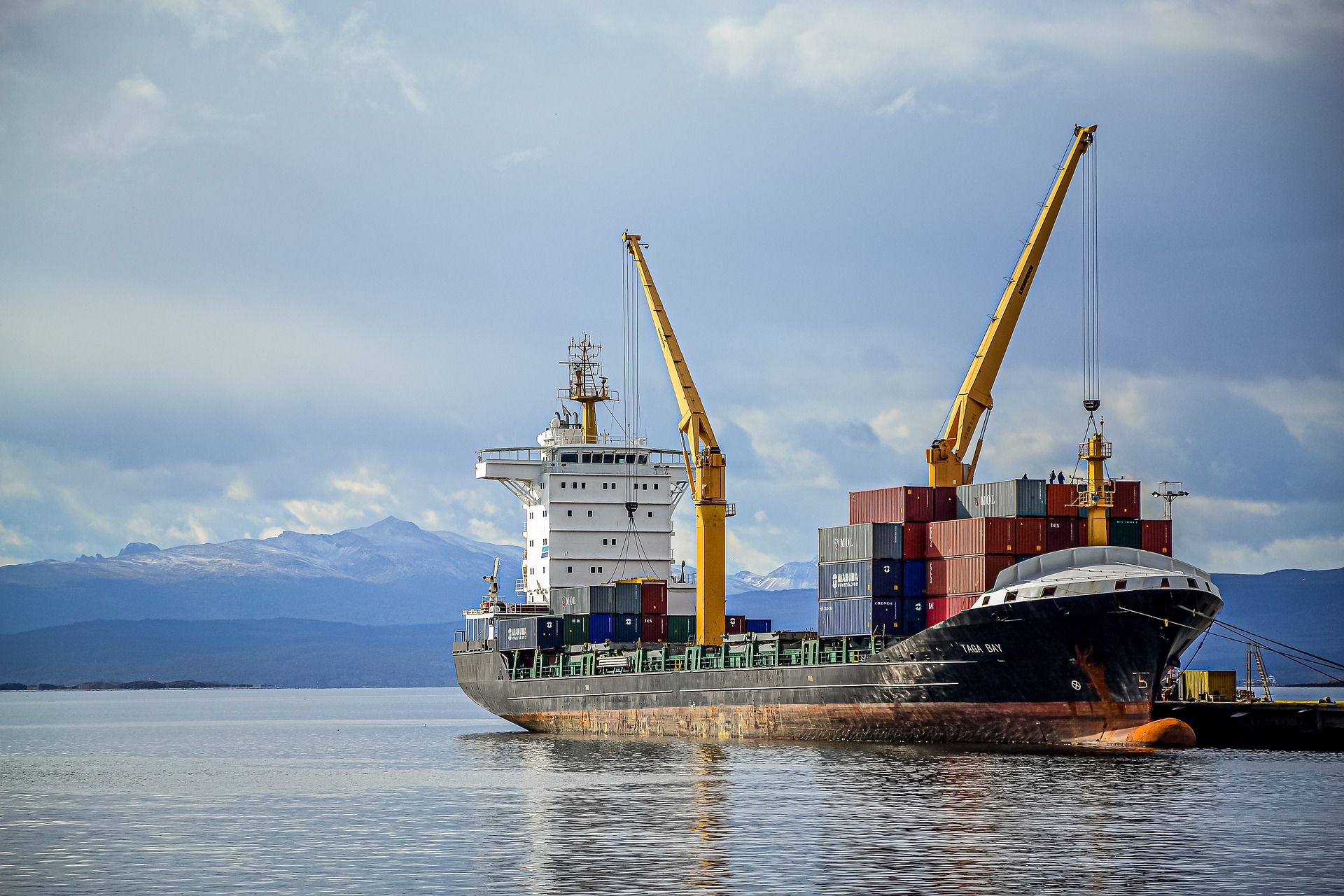 A cargo ship with a crane loading containers