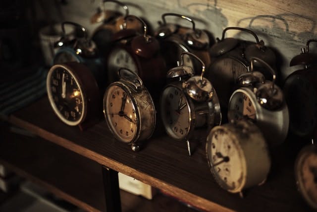 A bunch of clocks that are sitting on a shelf.