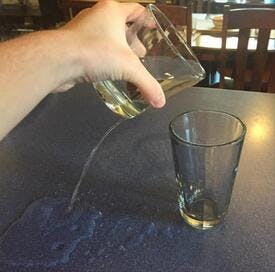 Failed attempt to pour water from one glass to another