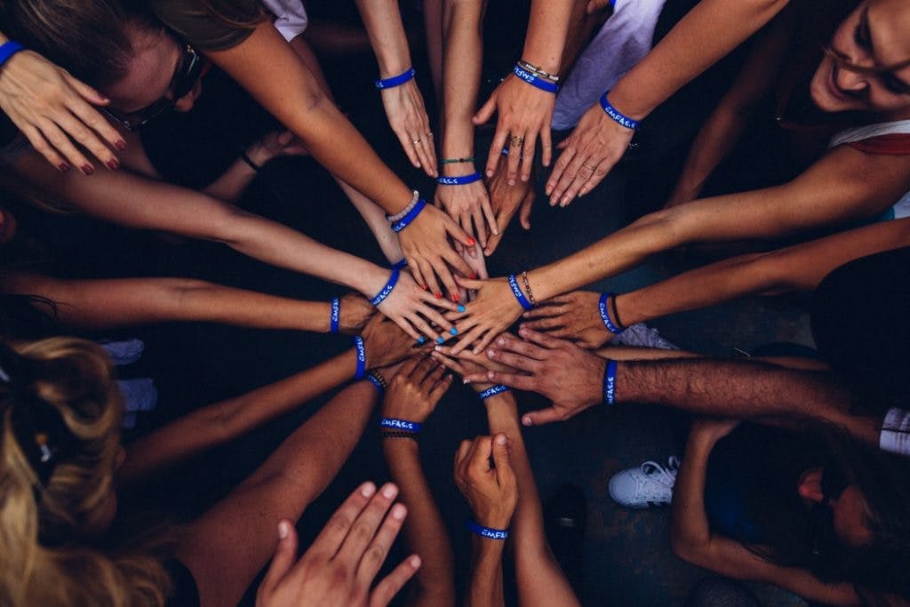 group of people putting hands together