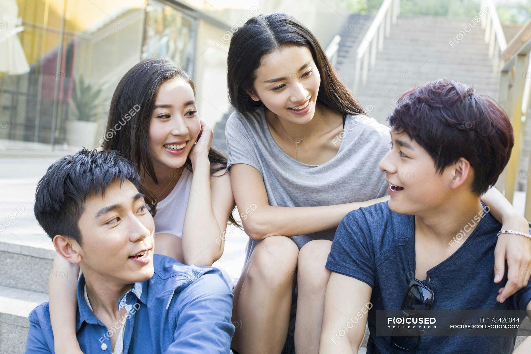 focused_178420044-stock-photo-chinese-friends-talking-together-stairs.jpg