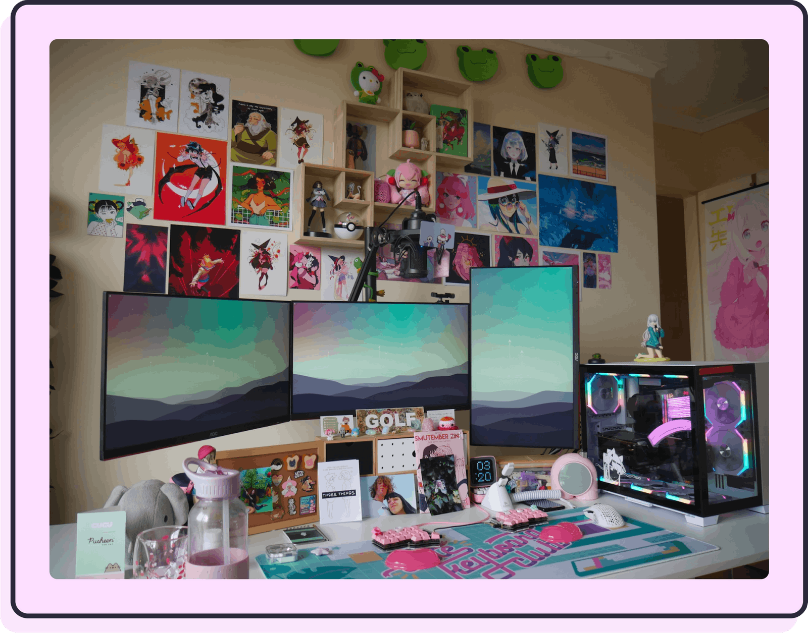 A photo of my desk and computer setup which is absolutely covered with prints, figurines, pins, zines, stickers, and much more.