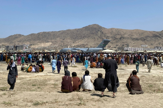 Hundreds of people gather near a U.S. Air Force C-17 transport plane at a perimeter at the international airport in Kabul, Afghanistan, Monday, Aug. 16, 2021. On Monday, the U.S. military and officials focus was on Kabuls airport, where thousands of Afghans trapped by the sudden Taliban takeover rushed the tarmac and clung to U.S. military planes deployed to fly out staffers of the U.S. Embassy, which shut down Sunday, and others. (AP Photo/Shekib Rahmani)