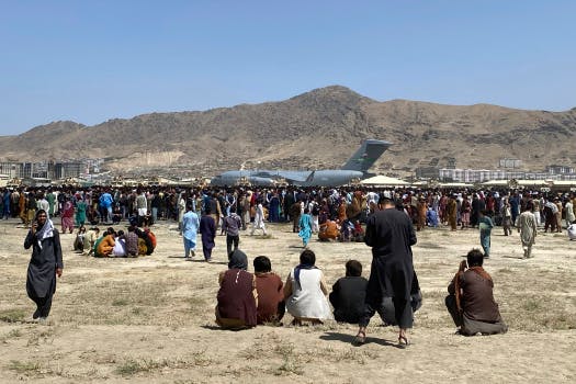 Hundreds of people gather near a U.S. Air Force C-17 transport plane at a perimeter at the international airport in Kabul, Afghanistan, Monday, Aug. 16, 2021. On Monday, the U.S. military and officials focus was on KabulÕs airport, where thousands of Afghans trapped by the sudden Taliban takeover rushed the tarmac and clung to U.S. military planes deployed to fly out staffers of the U.S. Embassy, which shut down Sunday, and others. (AP Photo/Shekib Rahmani)