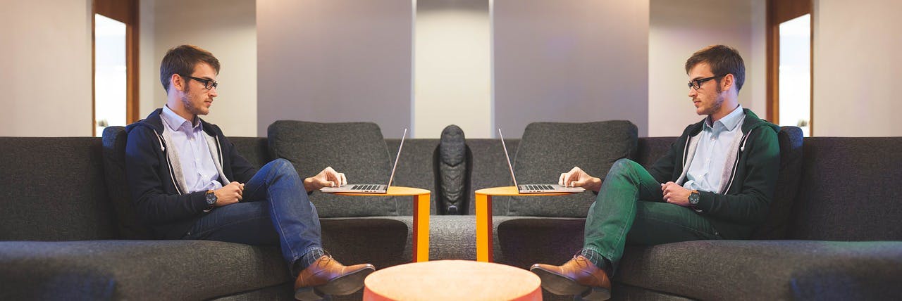 A picture of two guys sitting opposite each other wearing the same style of clothing albeit with somewhat different colours