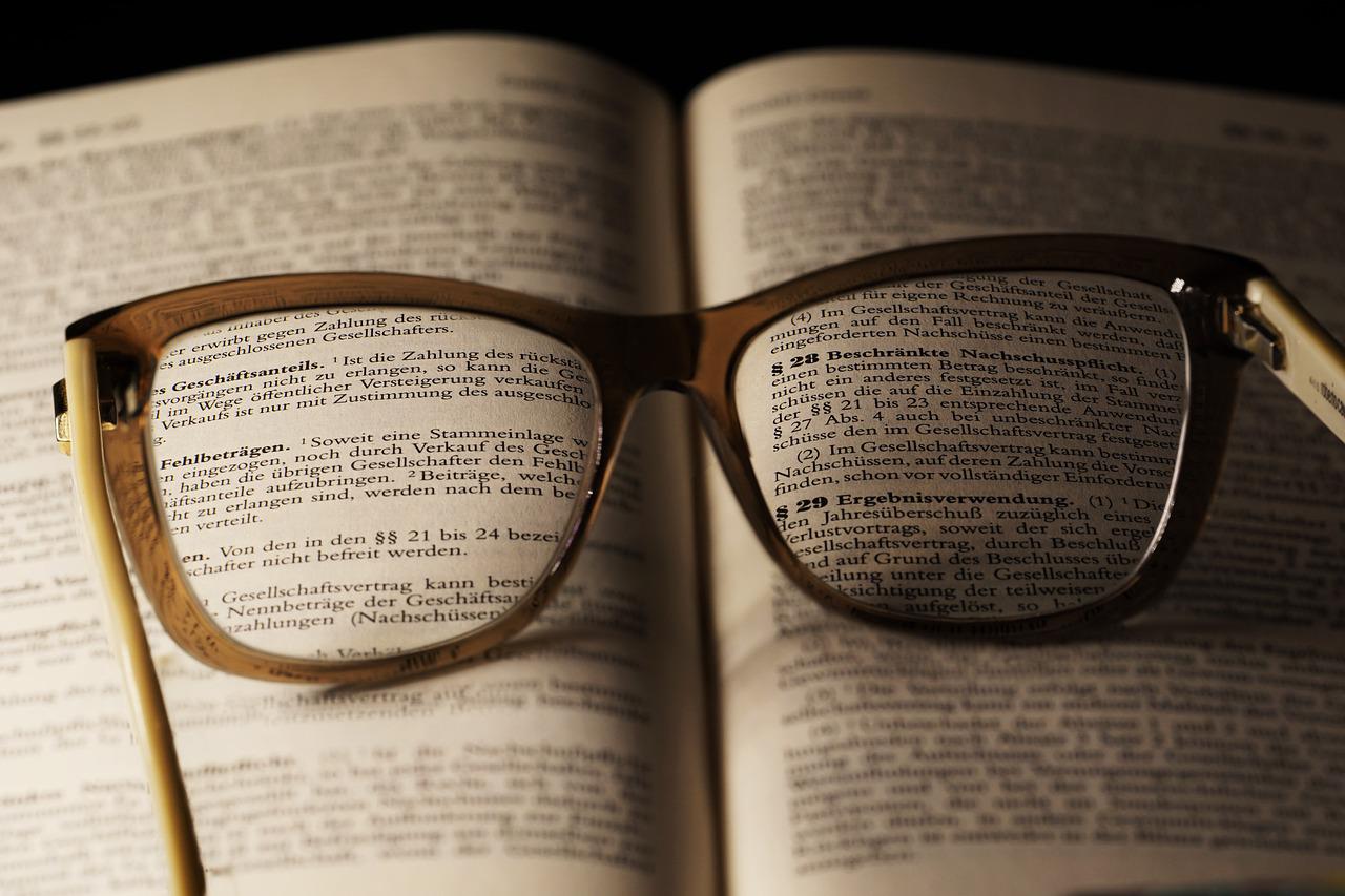 A pair of glasses in the middle of an opened book