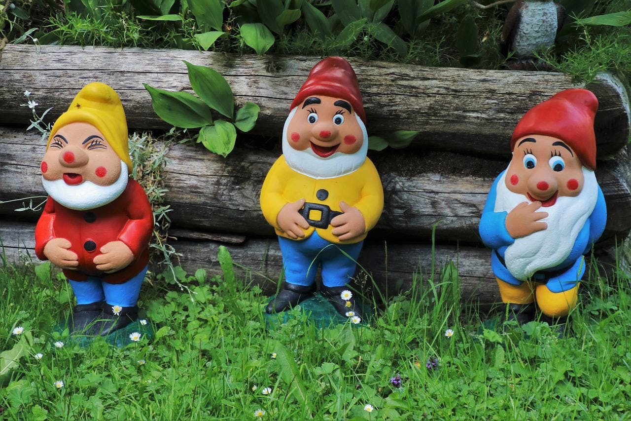 An image of three miniature toys in the woods