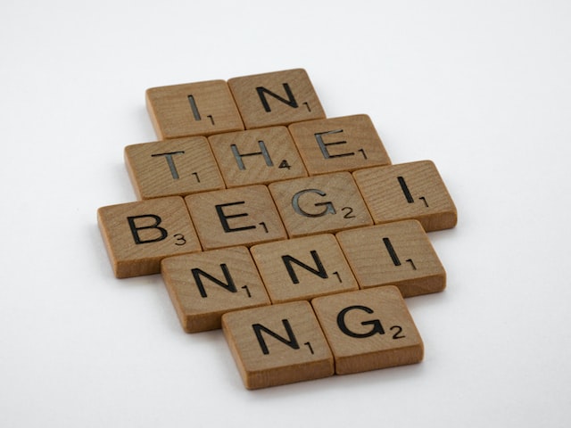 Wooden scrabble blocks with letters spelling out "in the beginning"