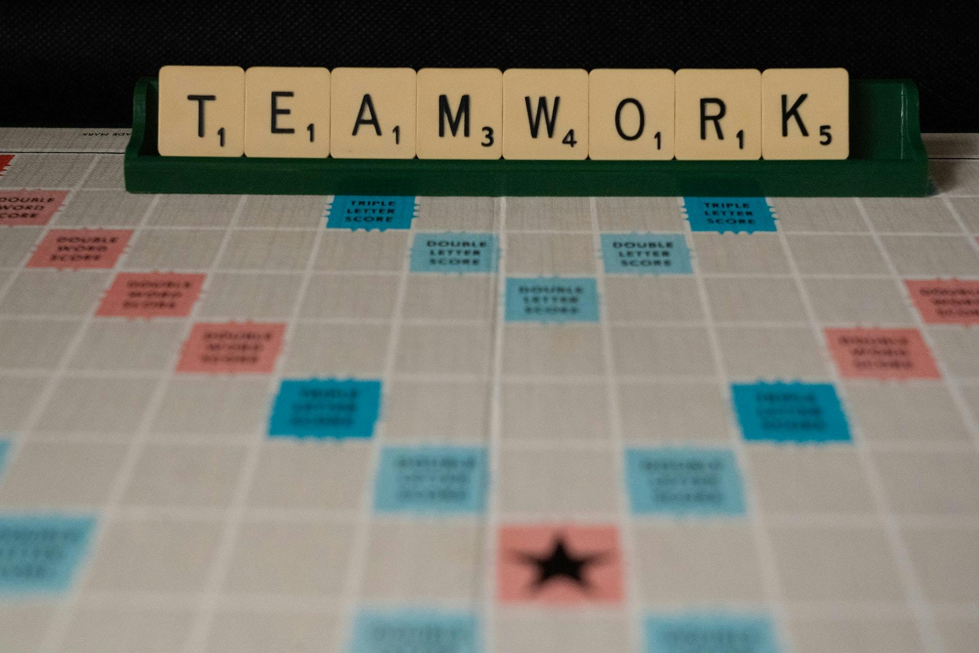 A scrabble board with words spelling teamwork.