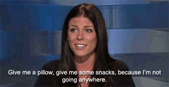 woman in gif with caption "give me a pillow, give me some snacks, because I'm not going anywhere"