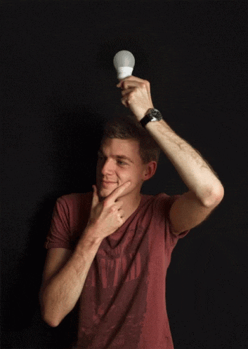 guy holding a lightbulb over his head with a look of contemplation as the lightbulb ignites