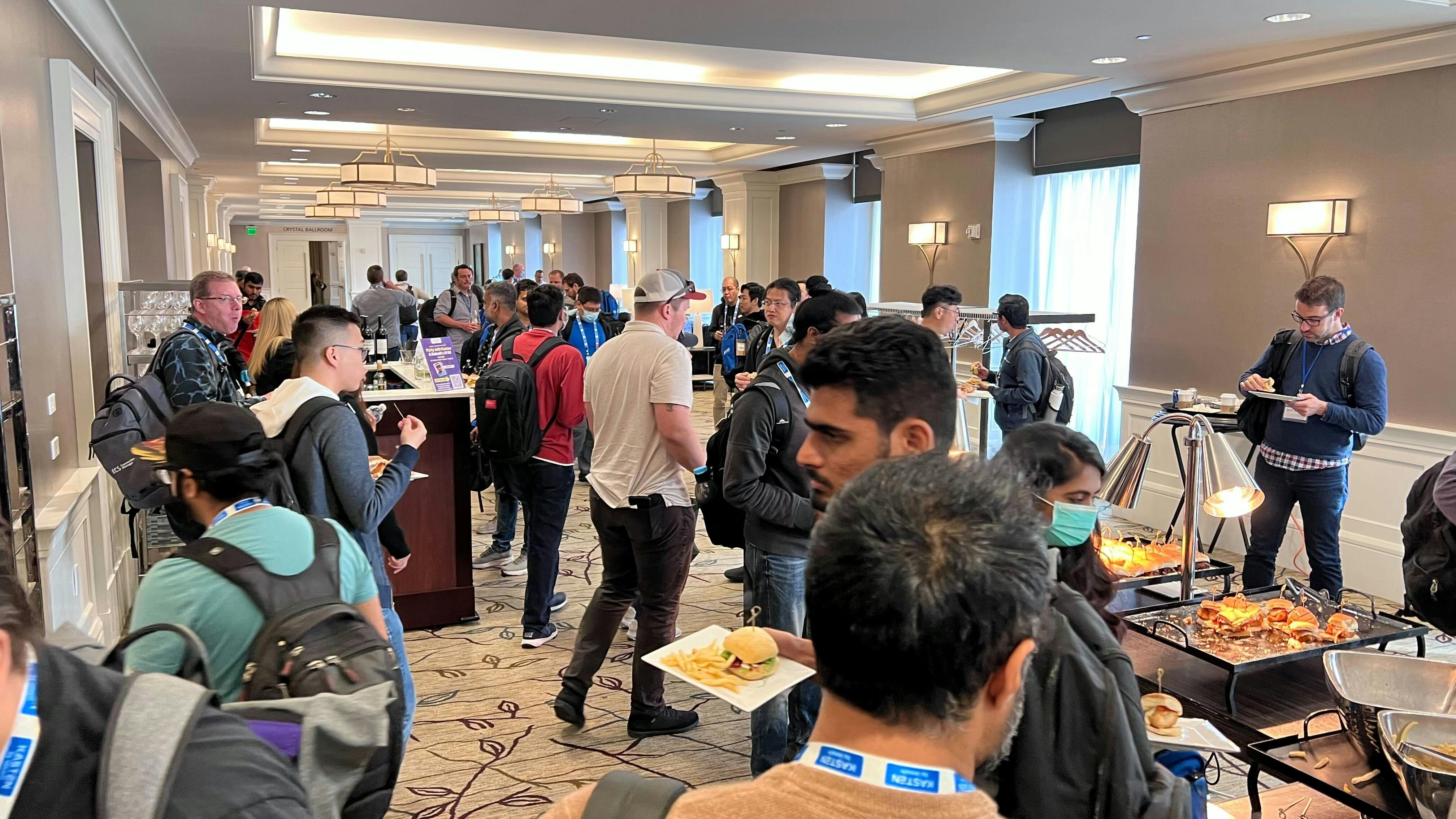 People mingling and eating at the Learning Day Featuring Kubernetes hosted by Kasten