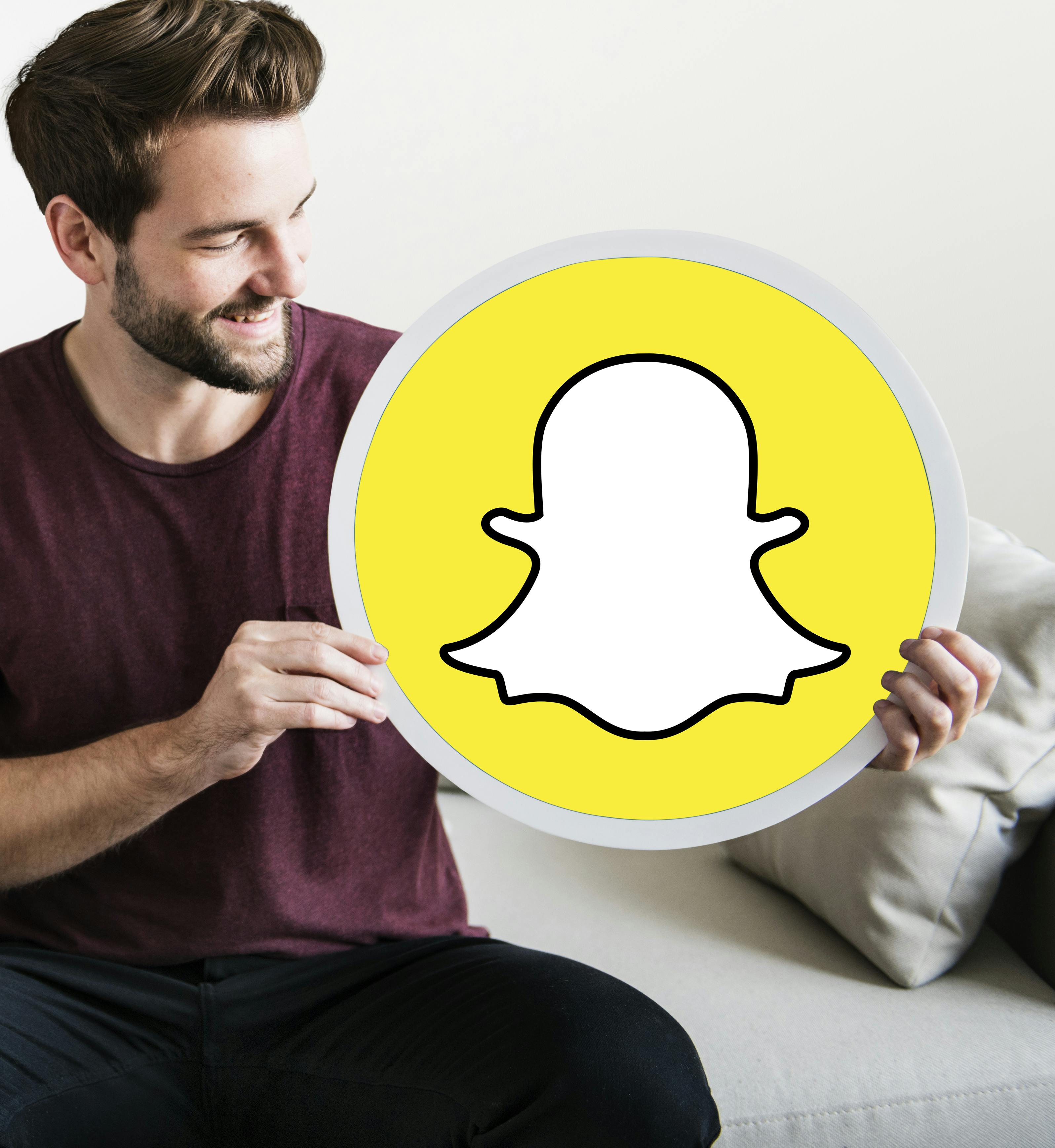 cheerful-man-holding-snapchat-icon.jpg