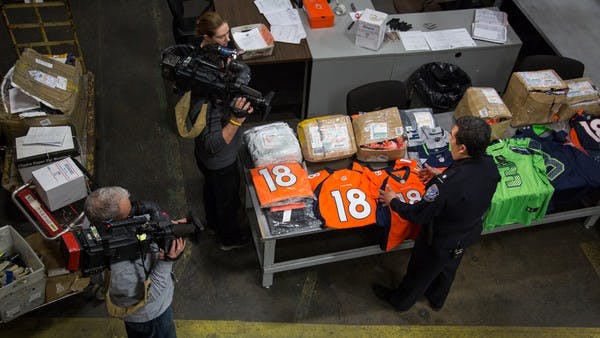 CBP officer inspects counterfeit sports apparel. Photo credit: U.S. Customs and Border Protection | Image Source: https://www.freightwaves.com/news/customs-brokers-see-role-in-combating-counterfeit-goods