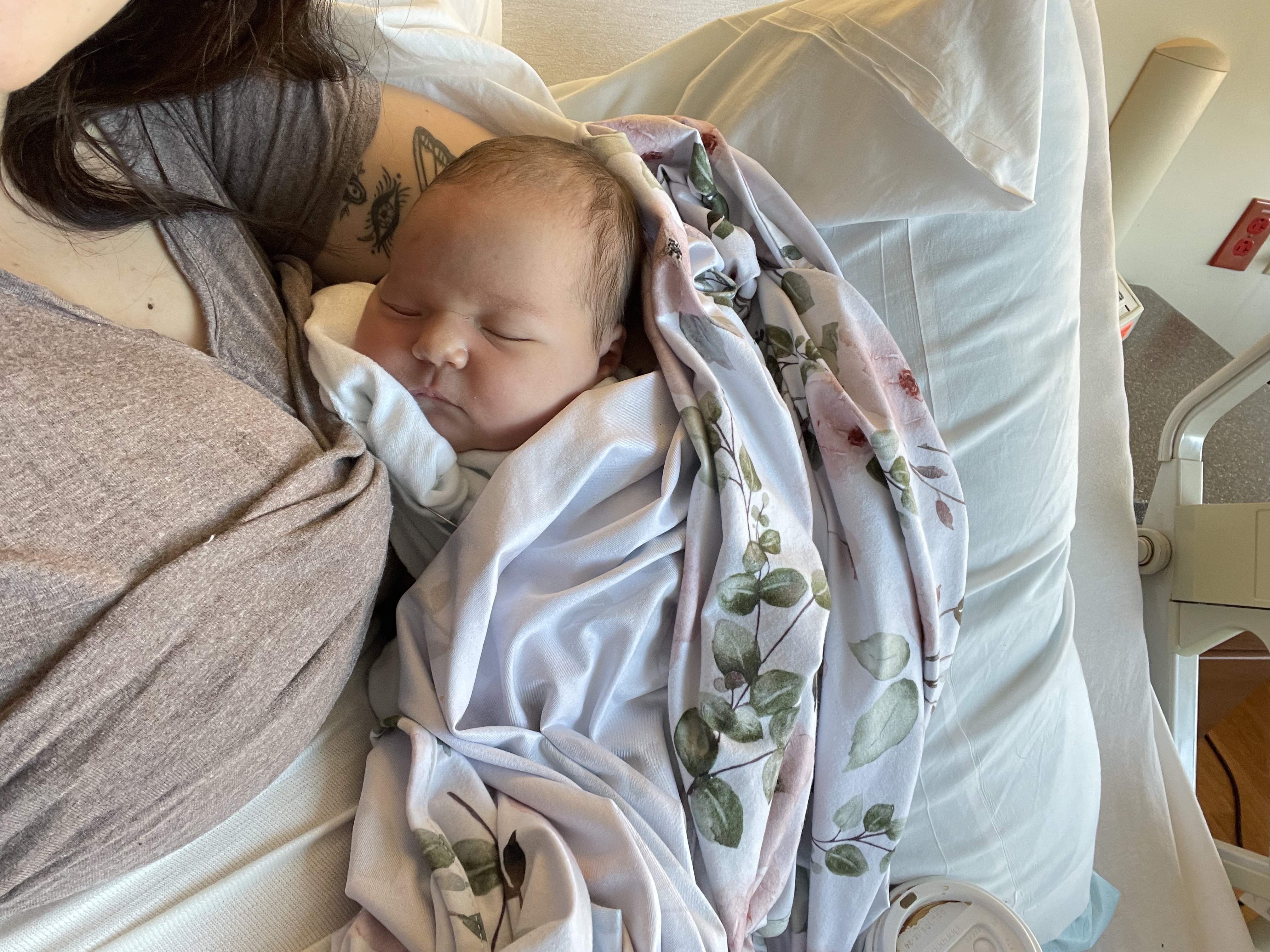 Me holding my daughter in the hospital the morning she was born. She is wrapped in blankets and sleeping.