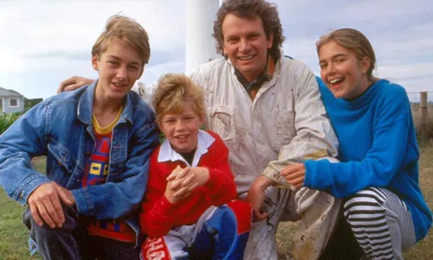 The Round the Twist family kneeling in front of a lighthouse