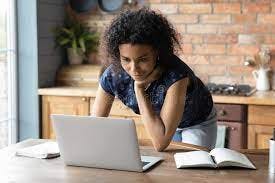  A girl in a clean environment, focused on her laptop.