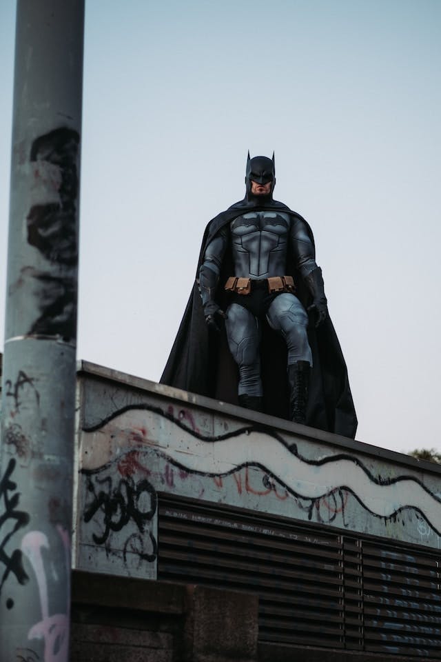 Batman on a roof looking at the camera