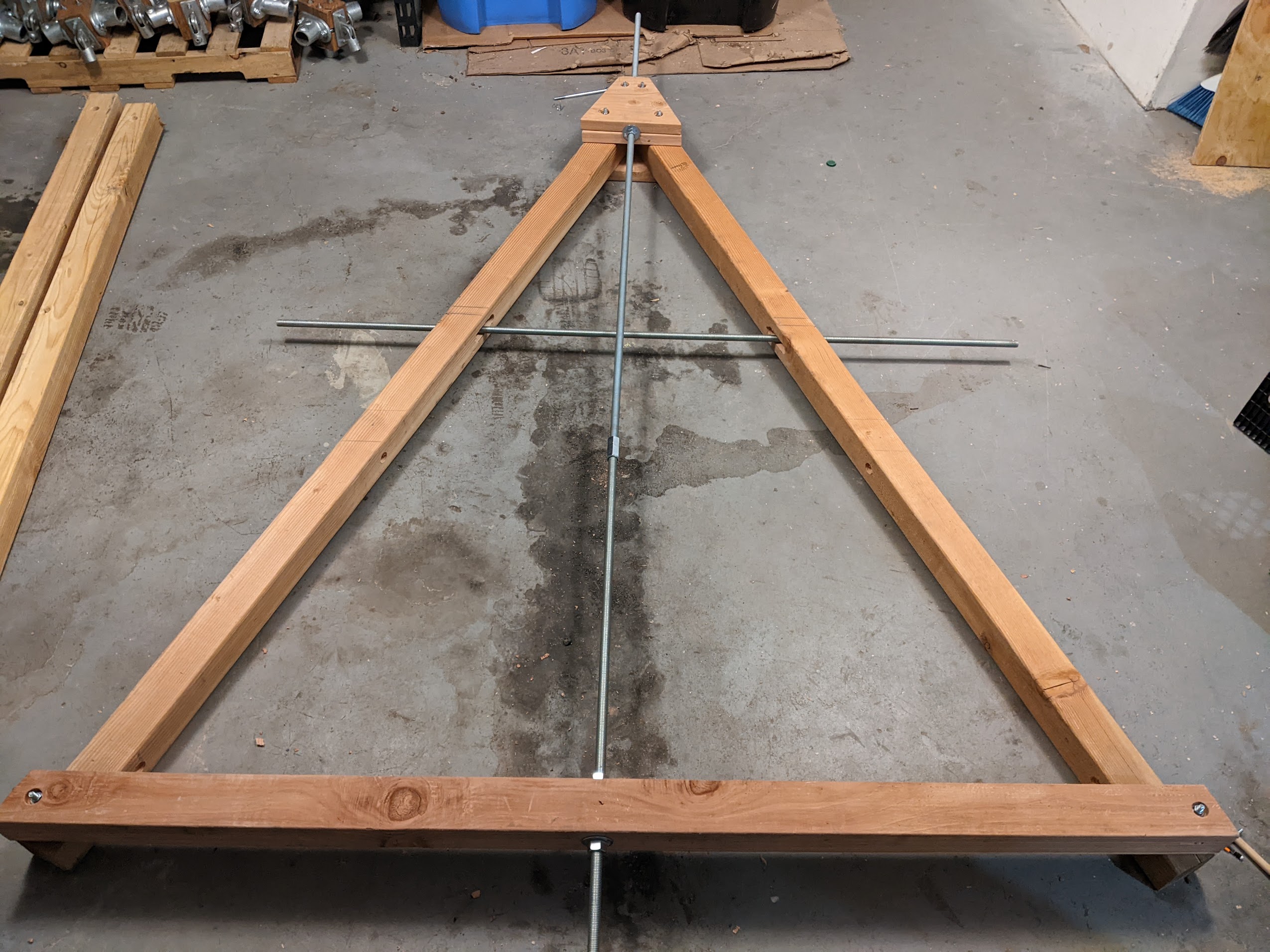 an A-frame on my garage floor. There's a metal cross held in its center made of threaded rod.