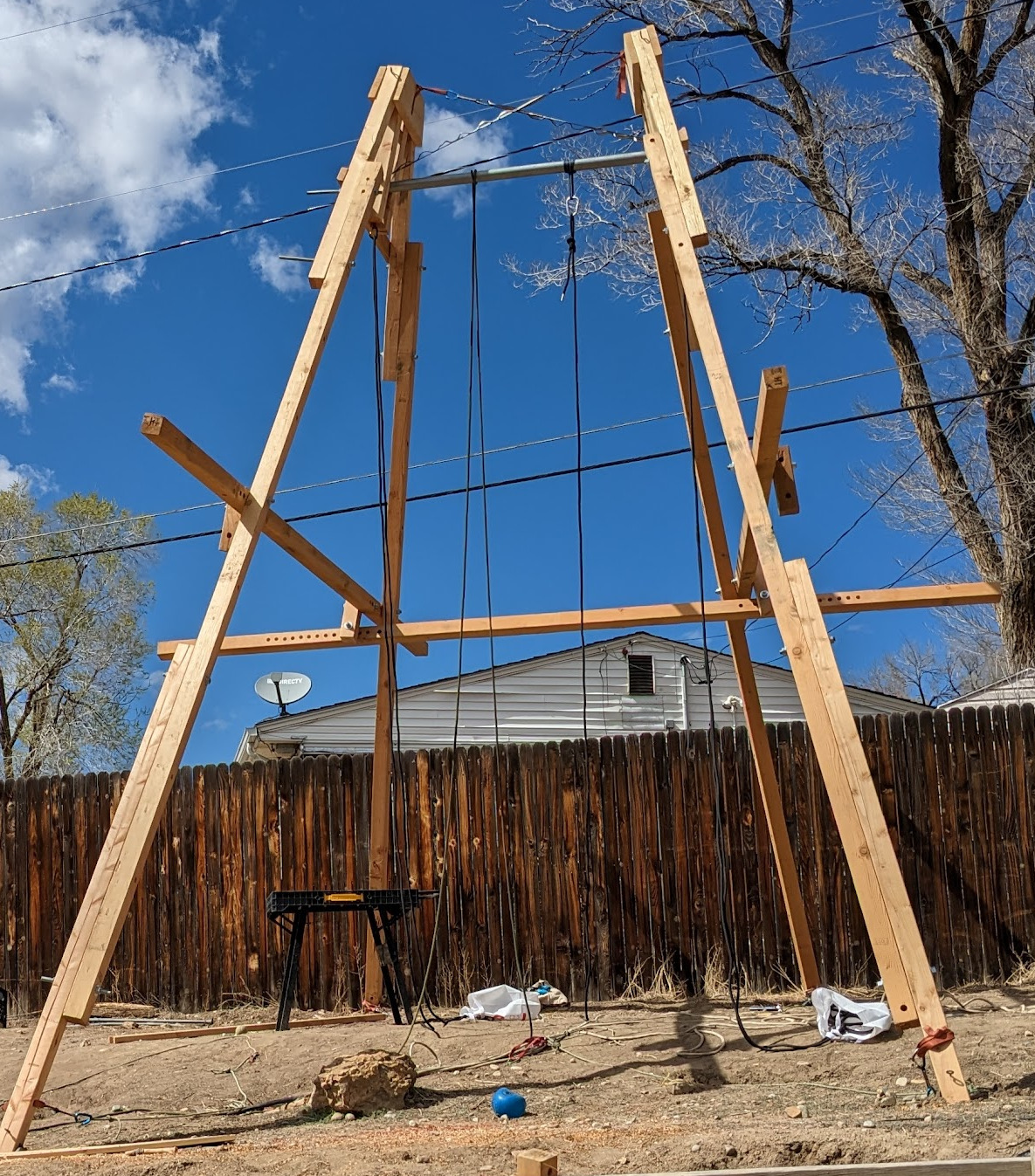 Two A's, mostly vertical, tops stabilized by straps, with a horizontal bar connecting them.  Three of four crossbeams attached at roughly eight feet above the ground.