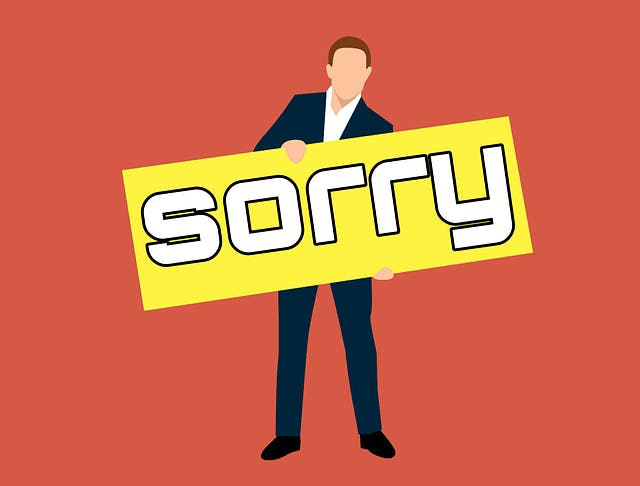 animated person holding a clipboard that says sorry