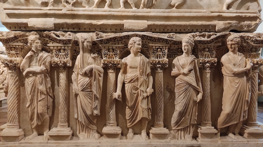 duy sarkofag z marmuru, ozdobiony rzebieniami kolumn i postaci w togach