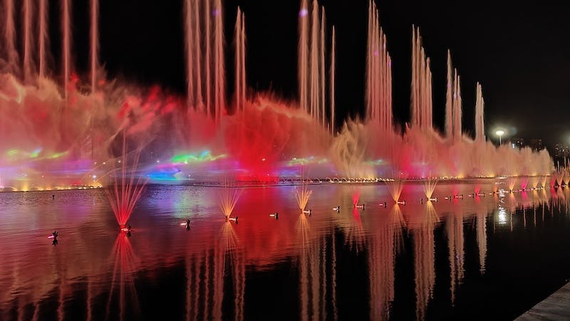 duża fontanna podświetlana na różne kolory w nocy