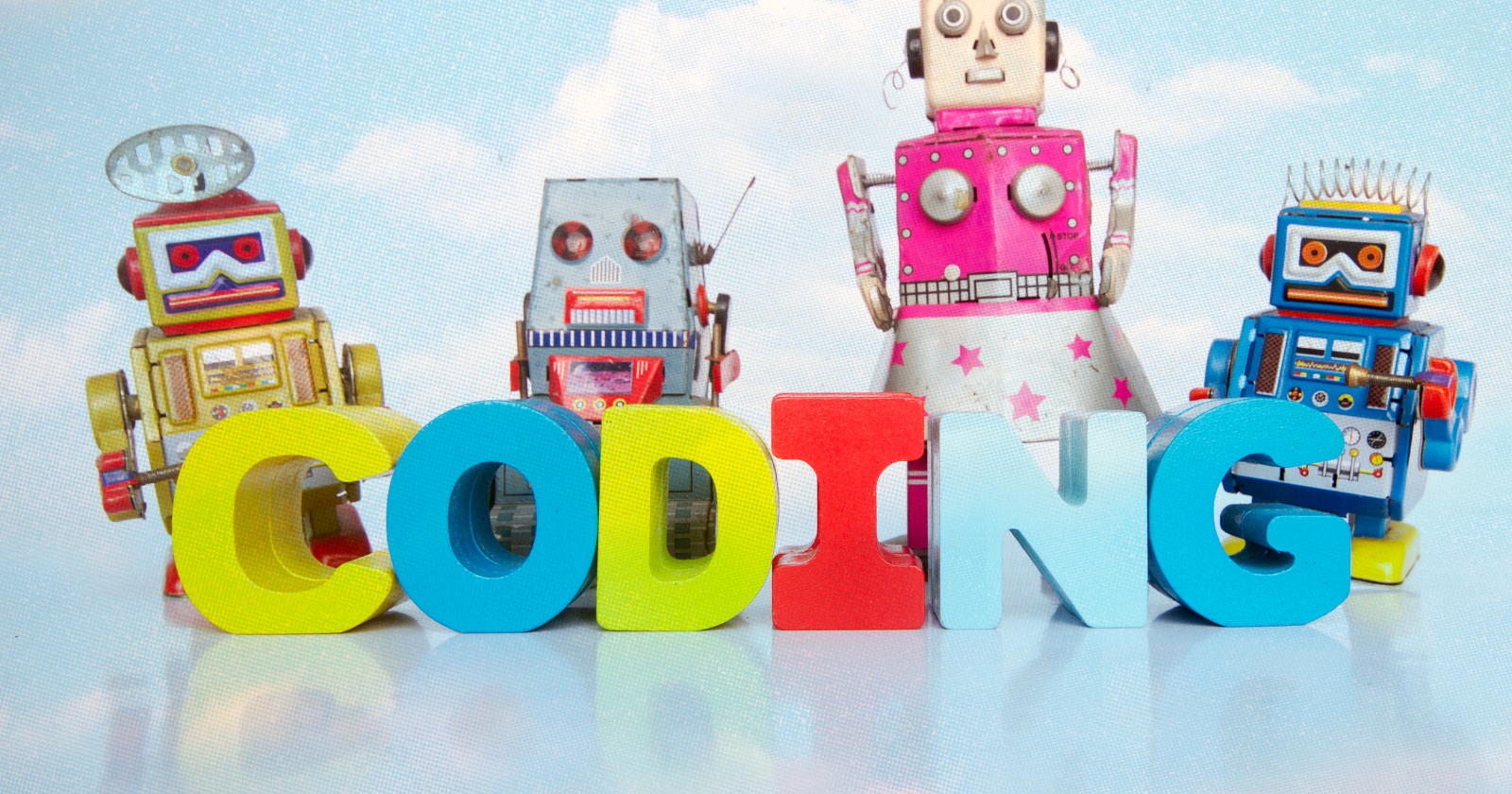 Toy robots beside 'CODING' blocks illustrating JavaScript learning