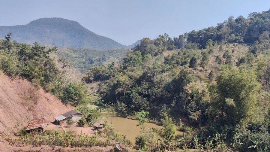 góry-pokryte-zielenią-gospodarstwo-laotańskie-przy-stawie
