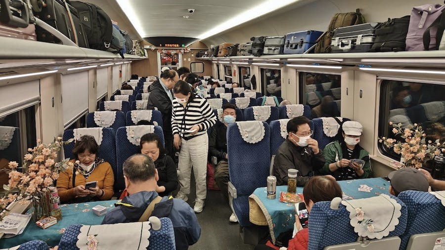 pasażerowie-rozsiadają-się-w-wagonie-kolejowym-duzo-bagażu-na-półkach