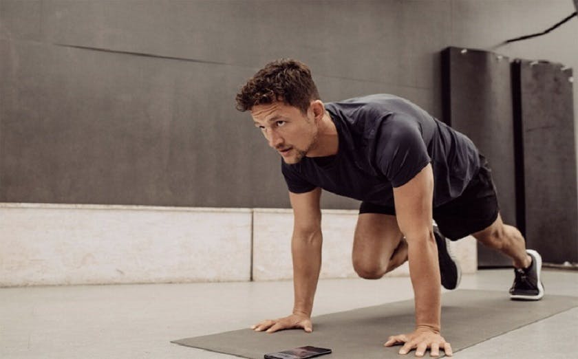 A man is doing 7-Minute push up workout on a mat