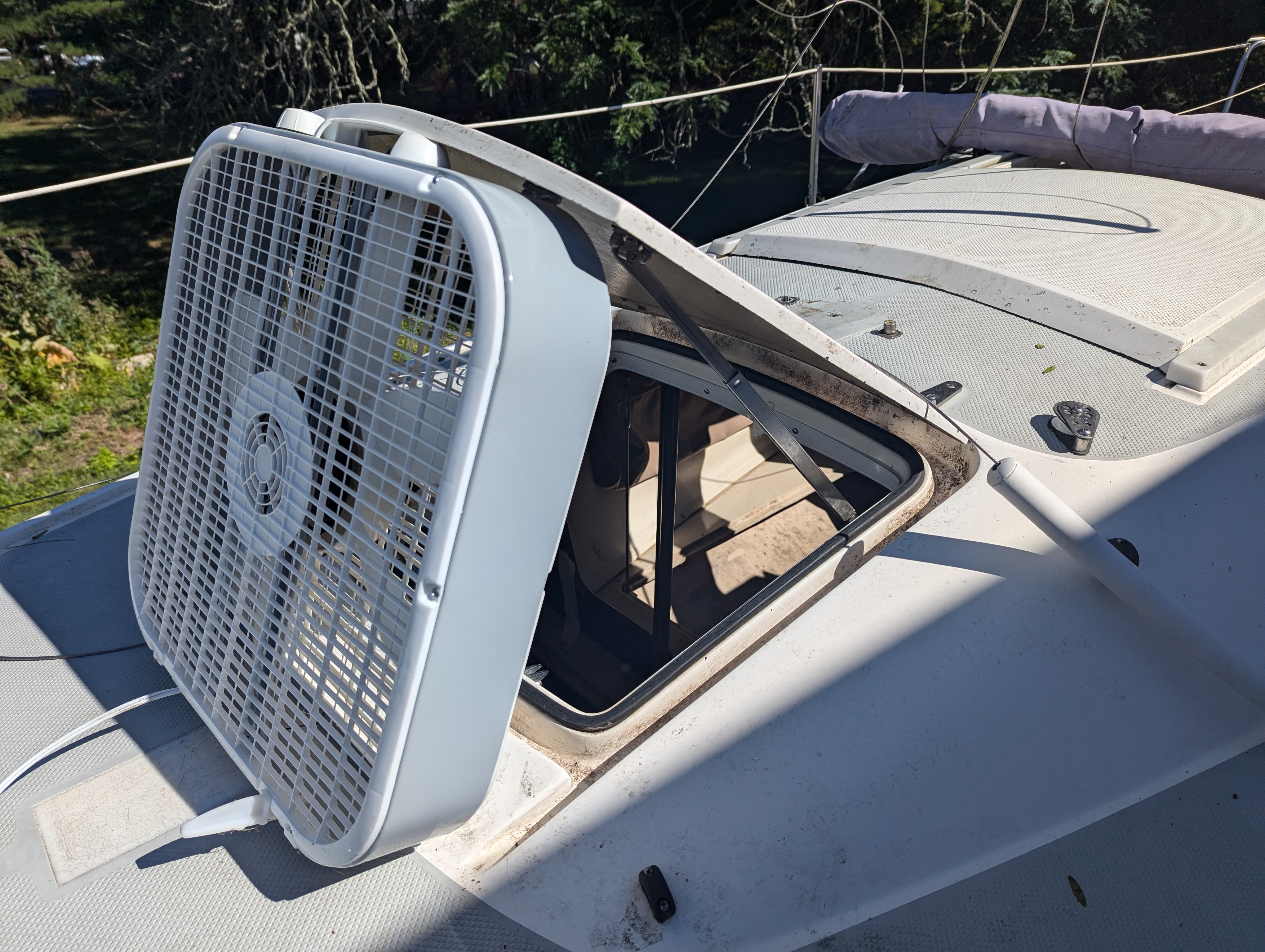 Fan blowing into open hatch on a boat.