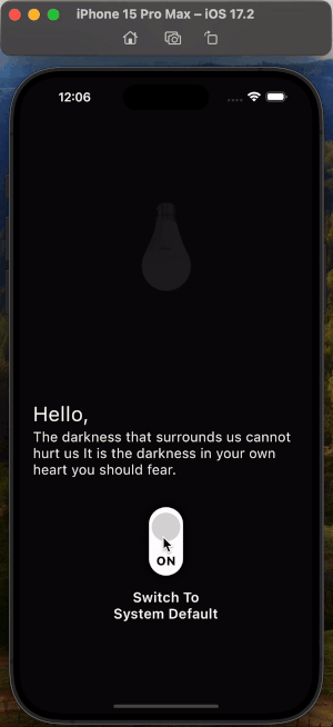 Application showing in both light mode and dark mode. A screenshot of an iPhone 15 Pro Max running iOS 17.2 showing a dark-mode screen with a lightbulb icon, a motivational quote that says, "Hello, The darkness that surrounds us cannot hurt us. It is the darkness in your own heart you should fear," and a toggle switch with the label "ON" and the text "Switch To System Default."