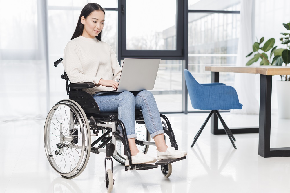 a women working on laptop with wheelchair in office