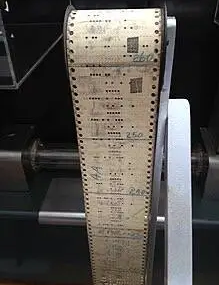 A program tape for the 1944 Harvard Mark I, one of the first digital computers. Note physical patches used to correct punched holes by covering them. Source: Wikipedia.