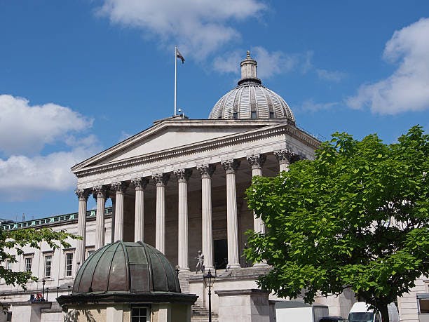 Neoclassical building with a large dome and columns, surrounded by greenery under a blue sky with clouds. Best place for international student.