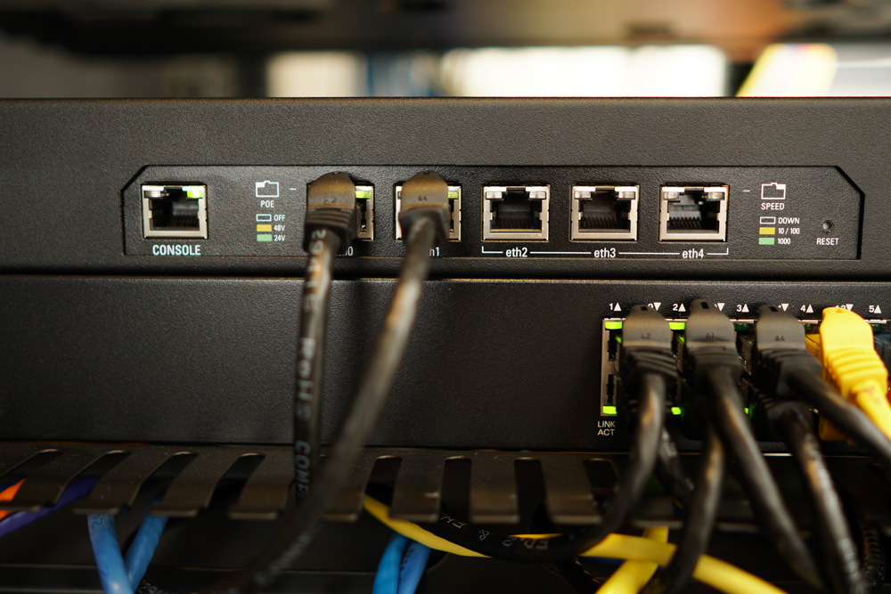 A close-up of a network switch with multiple Ethernet cables plugged into various ports.