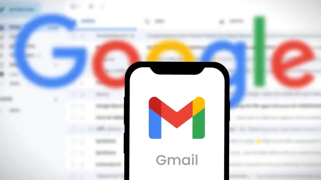 A smartphone displaying the Gmail logo in front of a blurred Google logo and email interface.