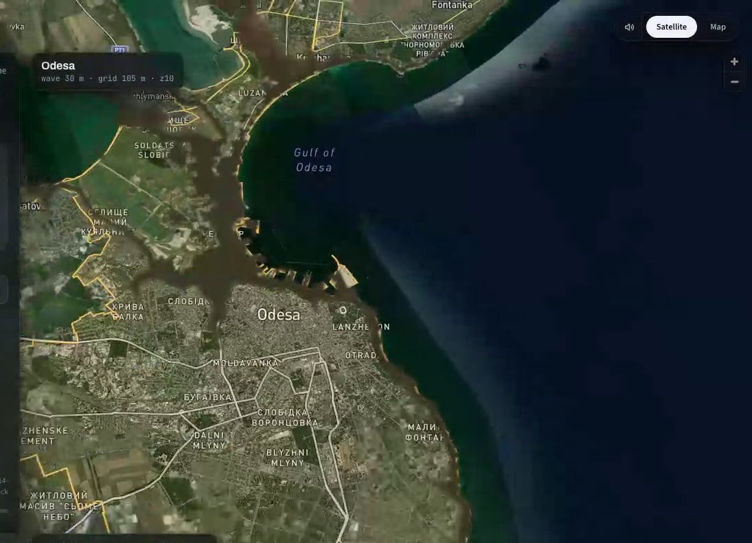 Top-down view of Odesa after the simulated tsunami. Dark brown water covers the low coastal districts and the port, following the shape of the coastline and stopping at higher ground inland. The open sea stays its normal dark blue.